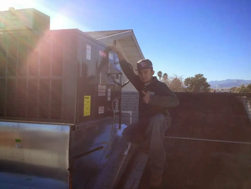 HVAC technician performing Heat Pump Repair on a rooftop unit in Huron